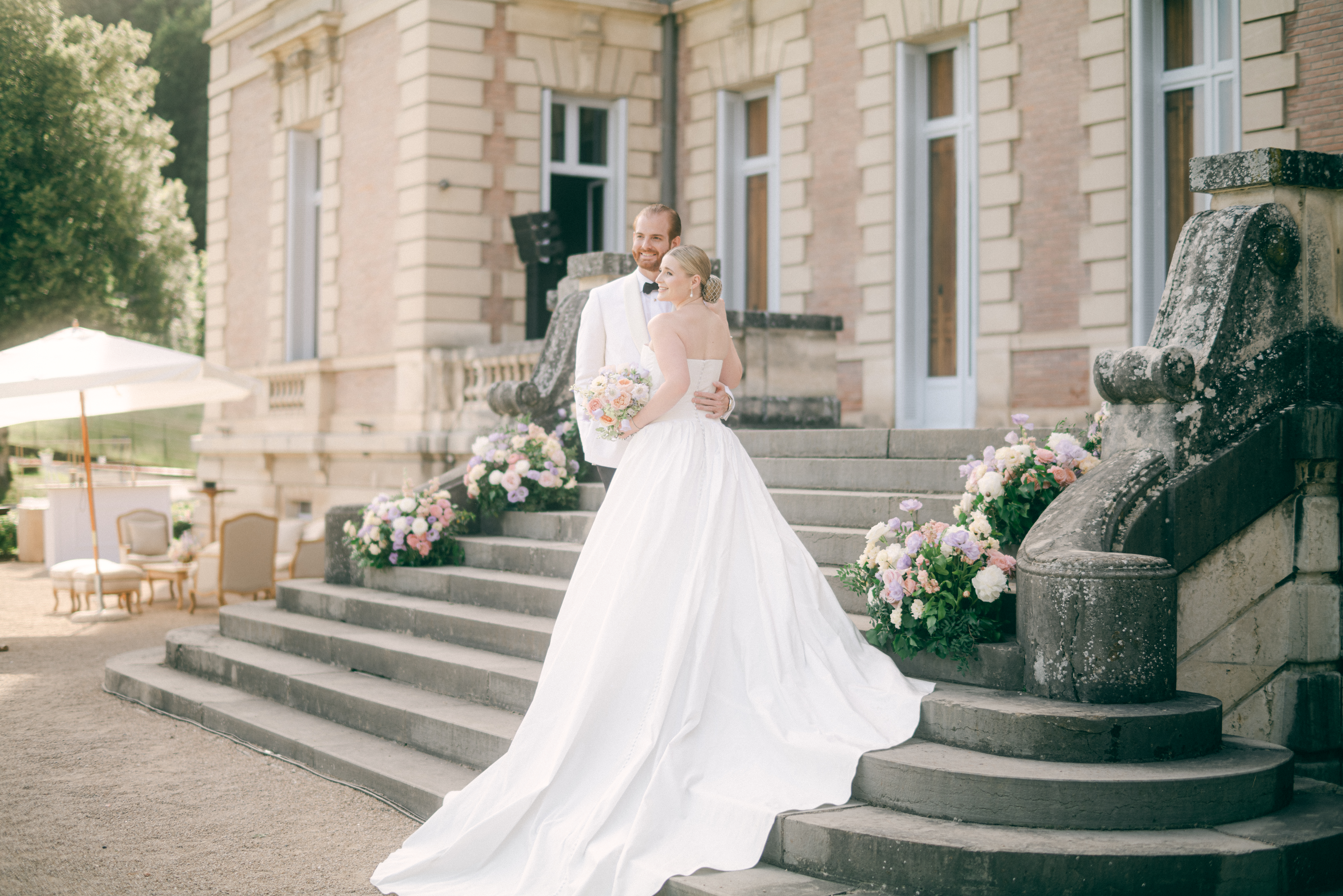 Allie and Parker sharing a quiet moment under the stars at Domaine des Halles, surrounded by candlelight and a grand château backdrop.