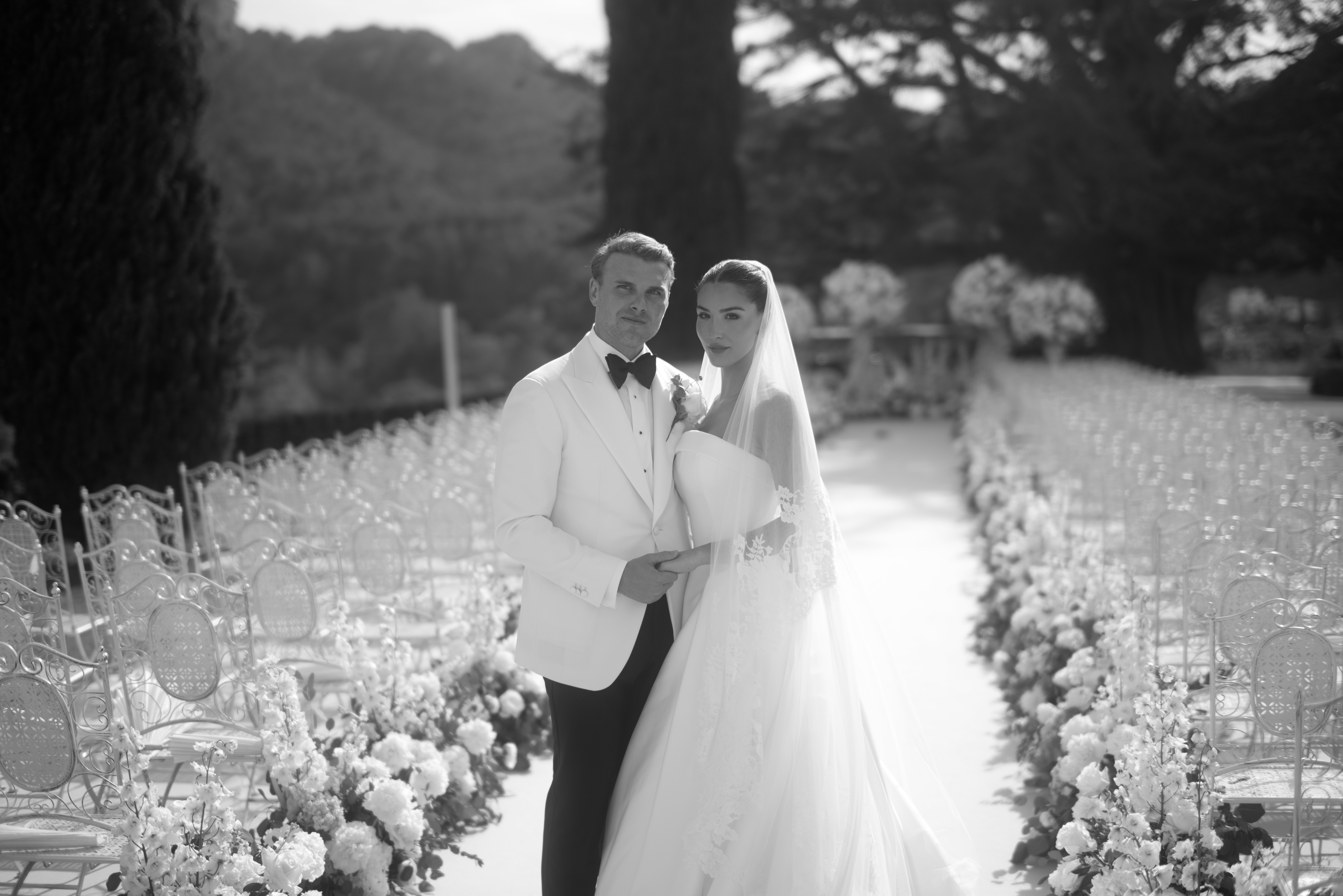 Sofia and Bay in front of a glass marquee, surrounded by lush floral arrangements at Grand Hotel Son Net, Mallorca.